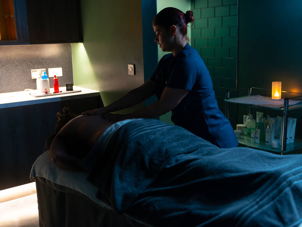 A person getting a back massage in one of the spa treatment rooms