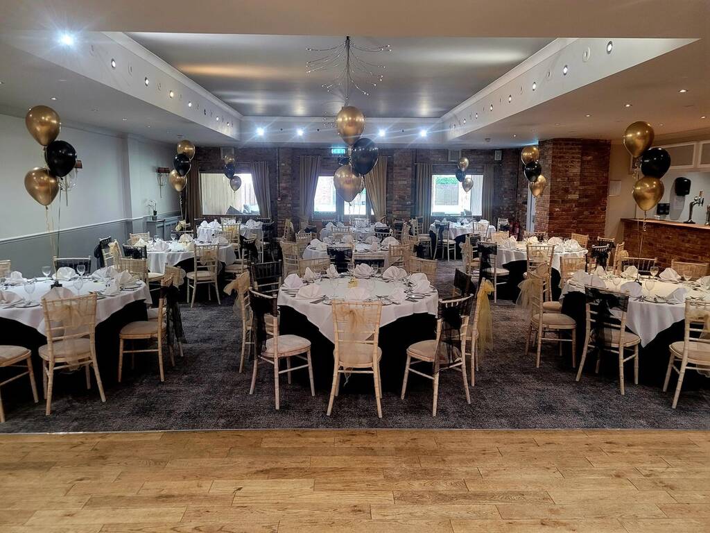 The Moat suite decorated with black and gold balloons