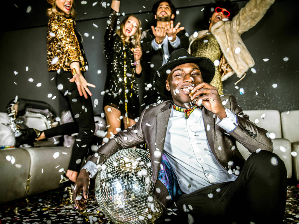 A picture of people partying with disco balls and confetti