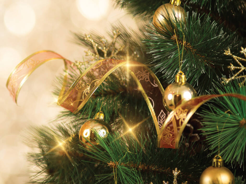 A stock image of close up of a Christmas tree with gold ornaments and ribbon