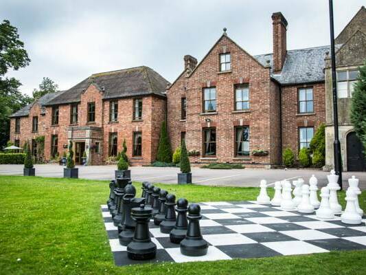 A picture of the Hatherley manor hotel exterior with a chess set