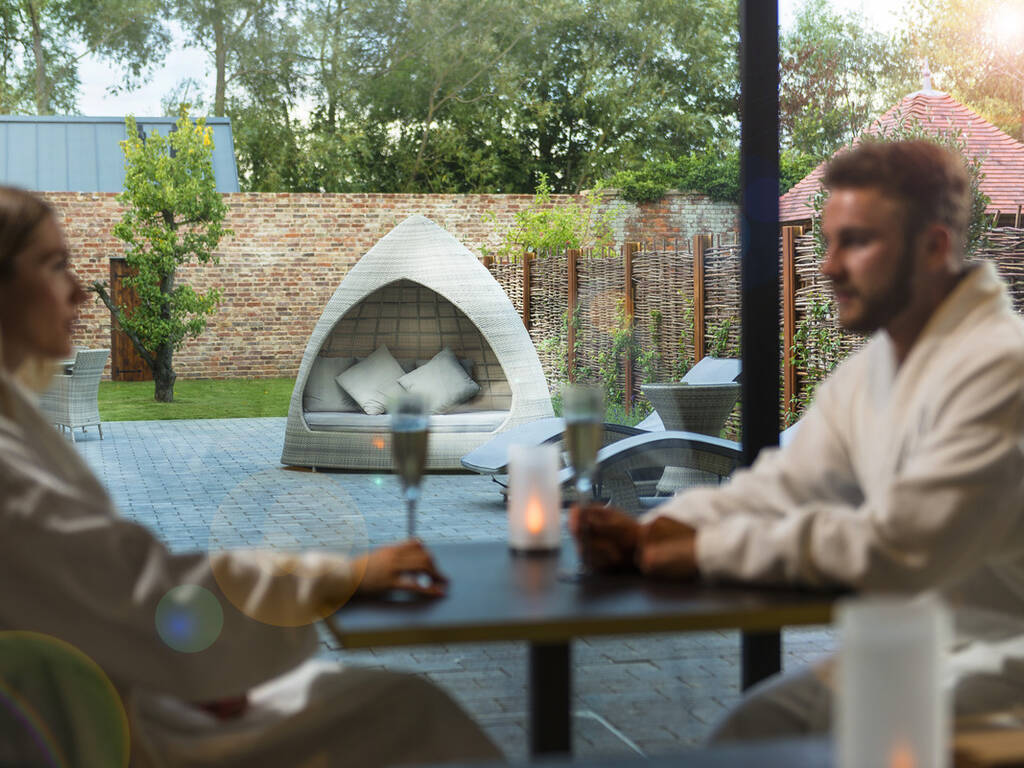 A picture of a couple enjoying drinks at the spa cafe overlooking the spa garden