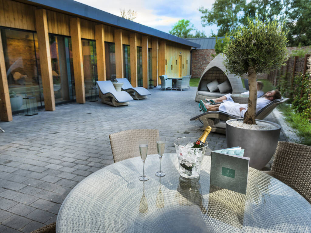 A picture of the spa garden with a bottle of Prosecco and two glasses on a table