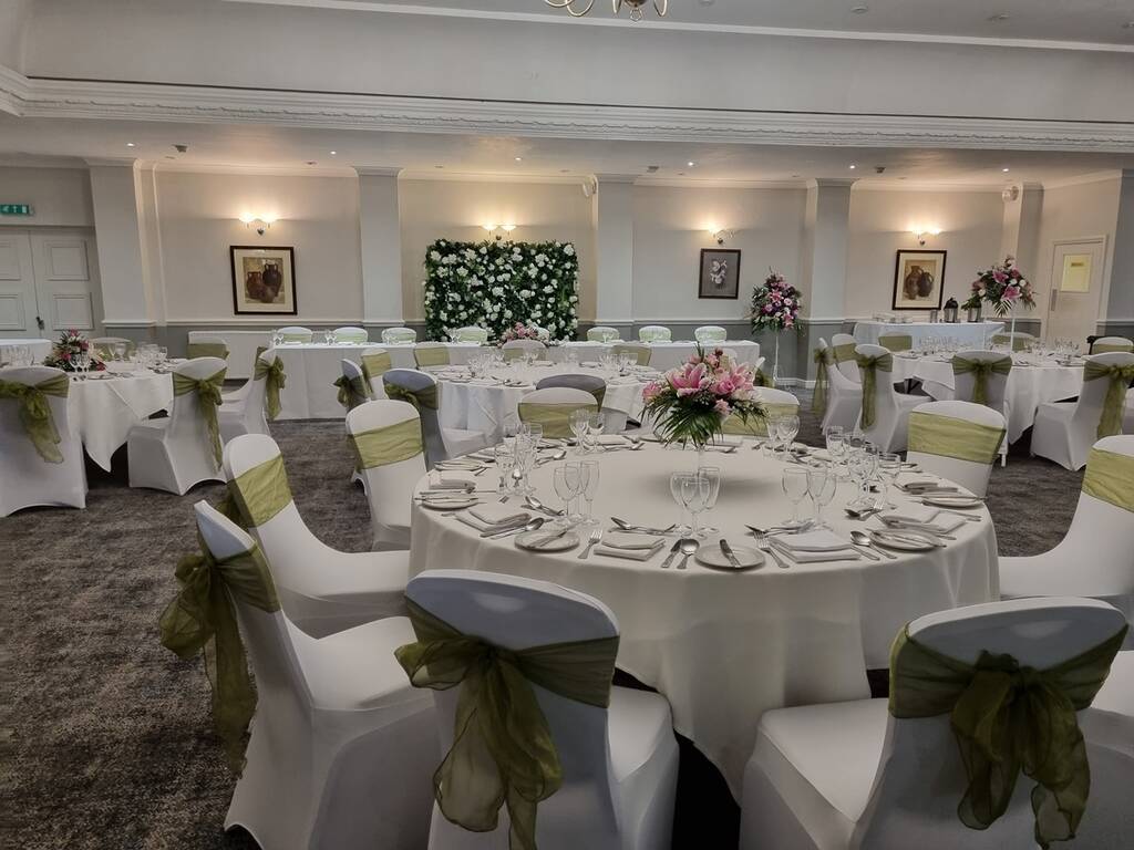 Hatherley Suite set up for a wedding with sage green sashes and flower decorations