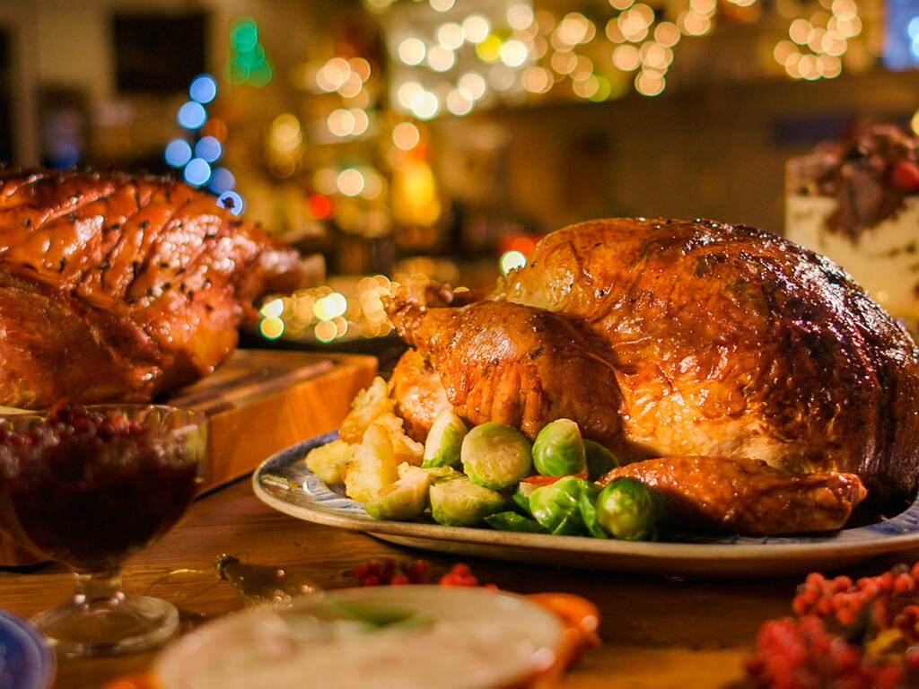 A picture of a Christmas dinner with Turkey on the table