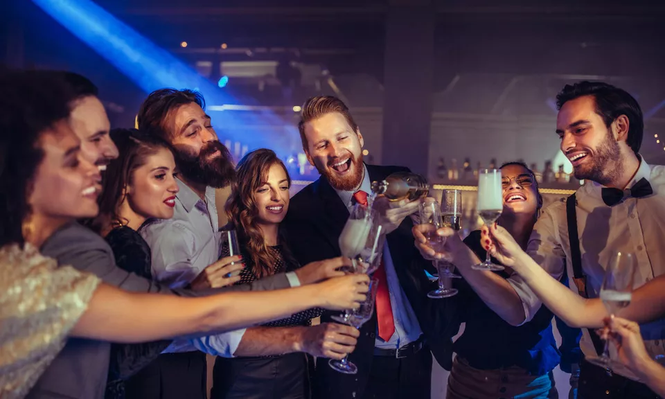 A group of people pouring drinks and smiling