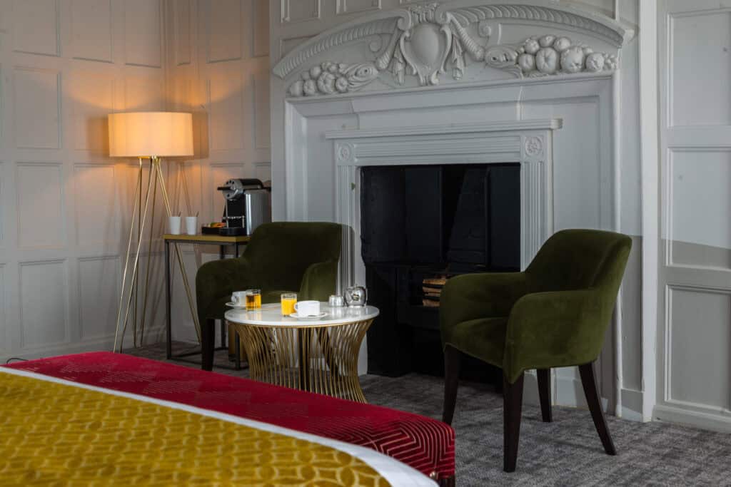 bed and fireplace at one of our rooms in Hatherley Manor, hotel gloucester