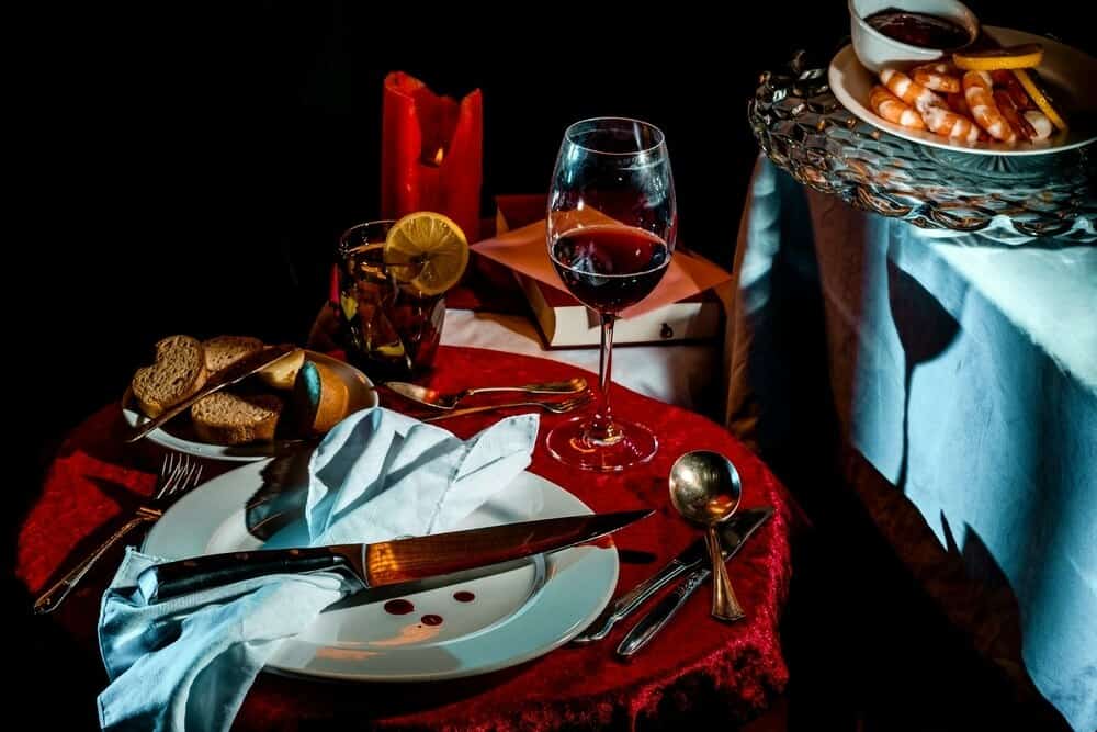 Murder Mystery set up with a bloody knife and glass of red wine on a table
