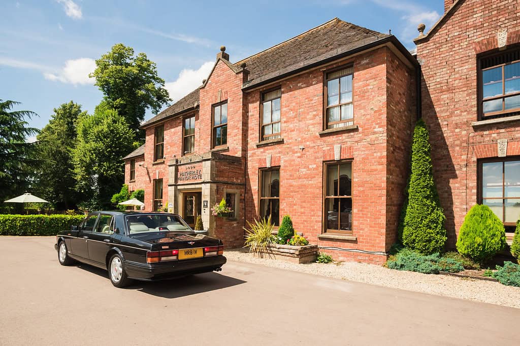 Car outside Hatherley Manor, an award winning wedding venue and 4 start hotel in Gloucestershire, Cotswold on a sunny day